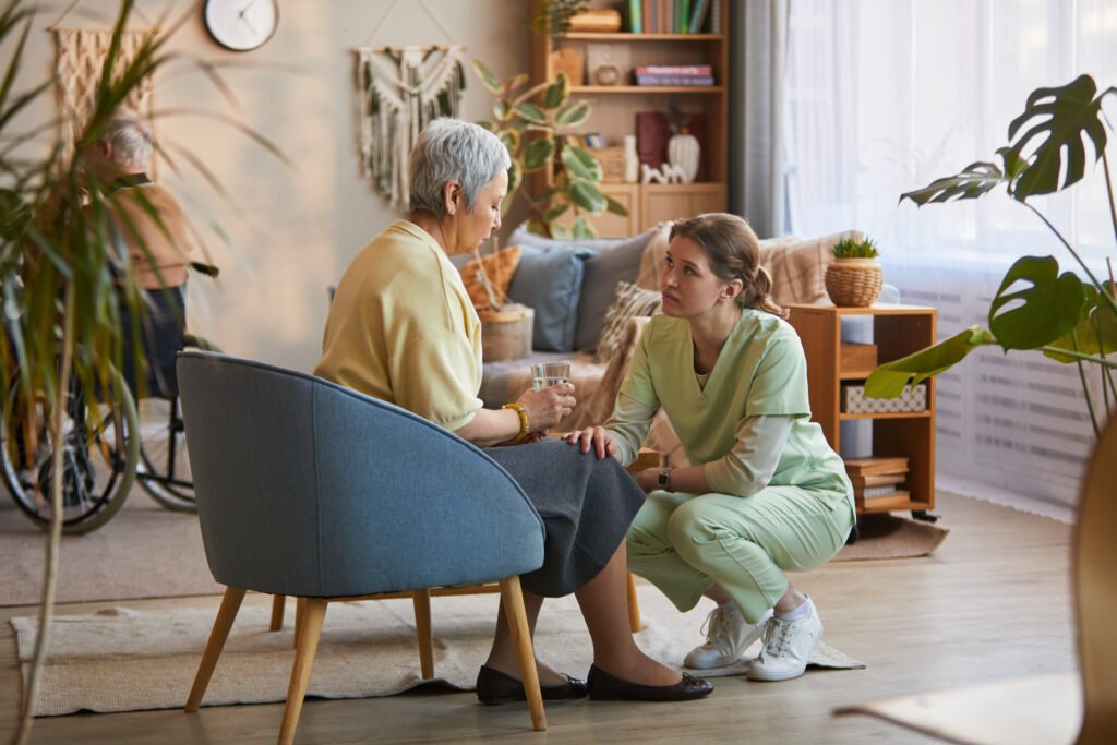 Begleitung einer Seniorin in Herne durch eine Betreuungskraft in einem Wohnzimmer